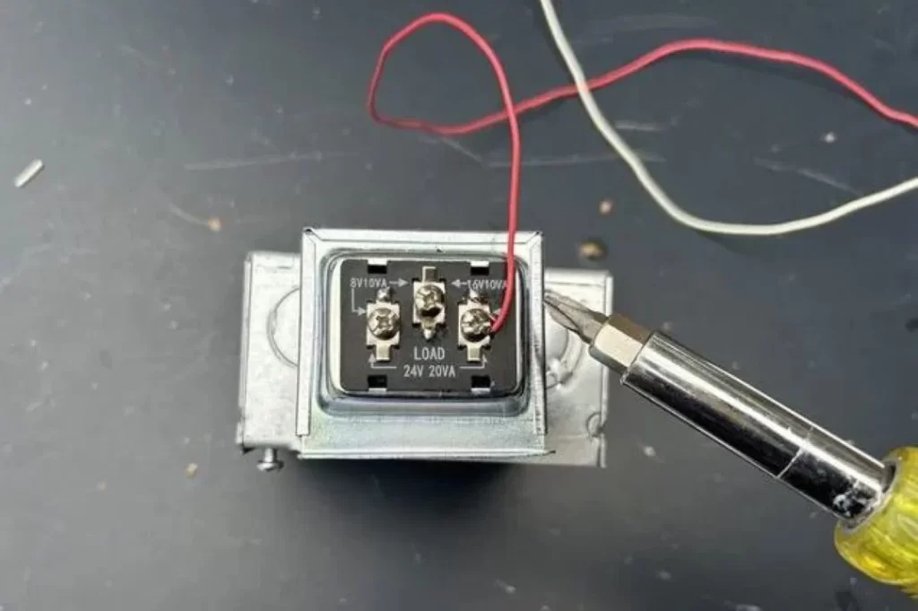 Pessoa testando uma campainha quebrada com ferramenta elétrica