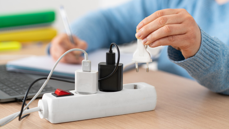 Computadores ligados na tomada elétrica durante o uso em ambiente residencial ou comercial