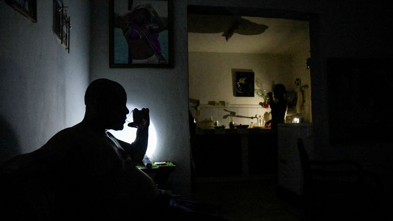 Família em um cômodo da casa no escuro durante queda de energia