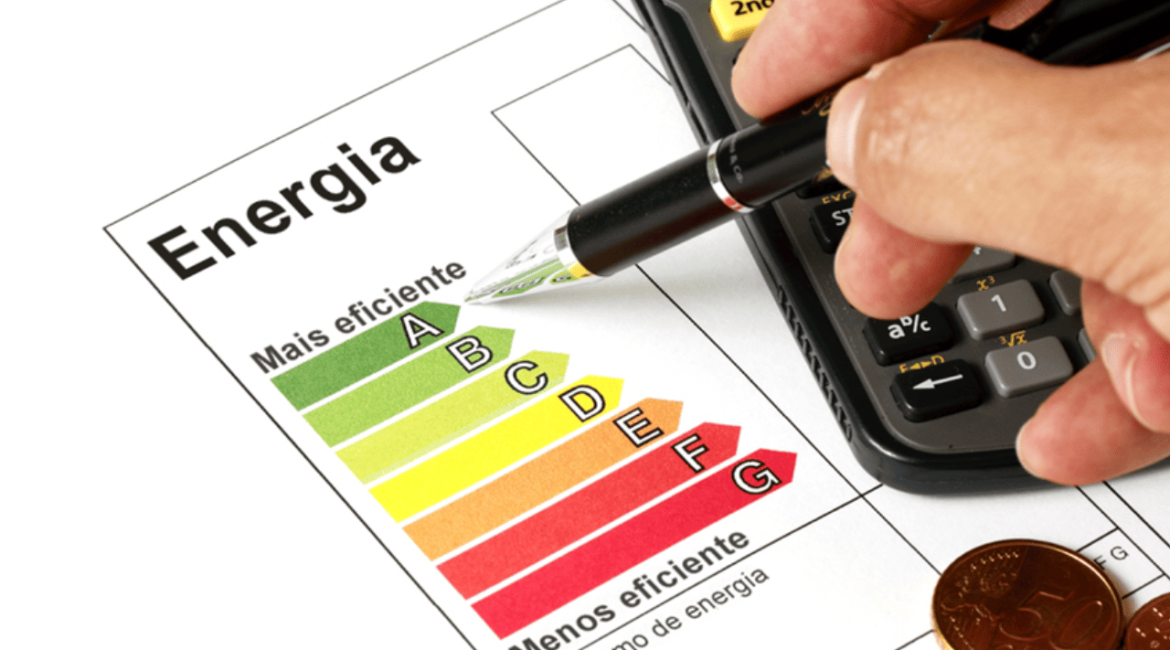 Mão segurando caneta e usando calculadora para reduzir a conta de energia