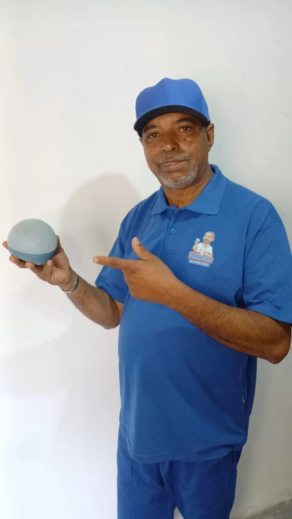 Seu Domingos Eletricista segurando dispositivo Alexa após instalar interruptores inteligentes em apartamento em São Paulo