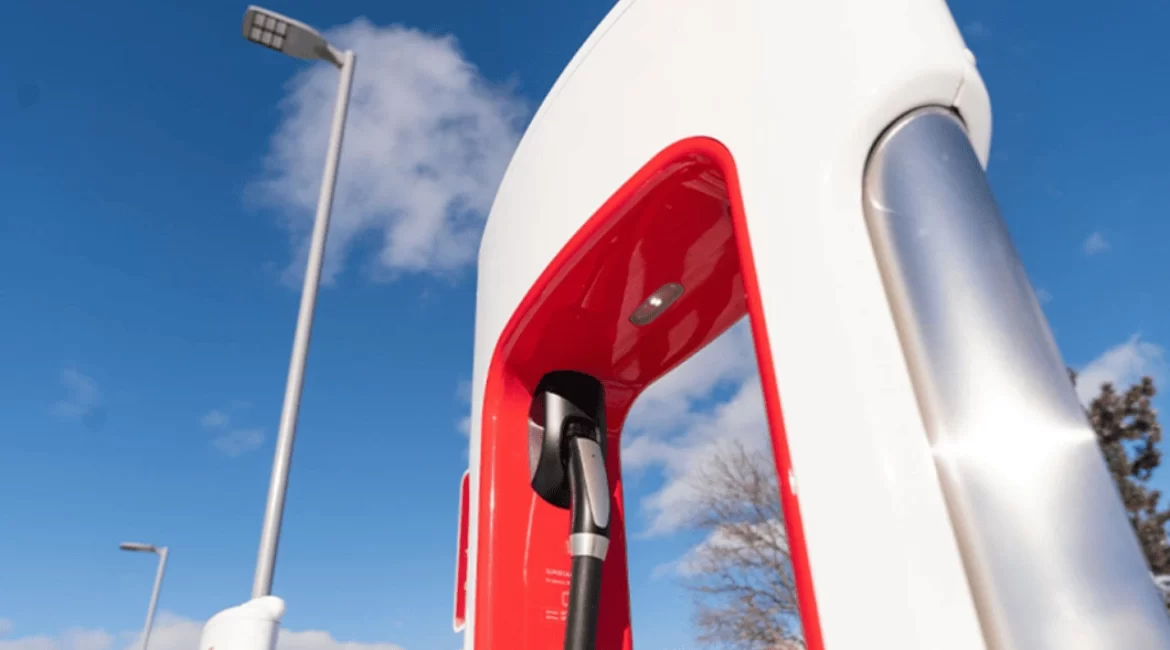 Carro elétrico conectado a carregador, ilustrando tempo de carregamento da bateria