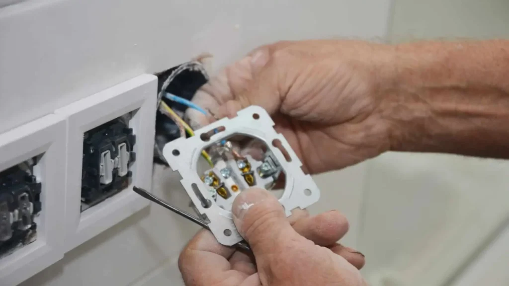 Tomada elétrica sendo instalada por eletricista profissional