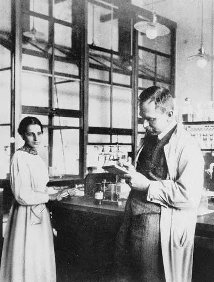 Lise Meitner e Otto Hahn em laboratório por volta de 1913