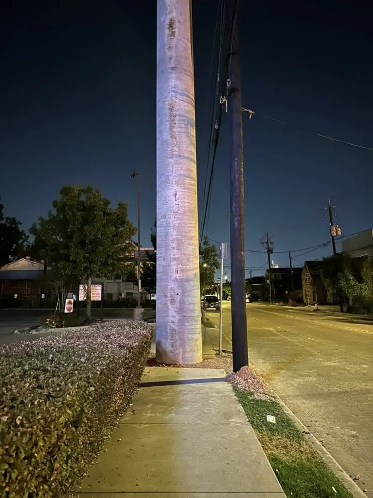 Poste de concreto sustentando rede elétrica em área urbana