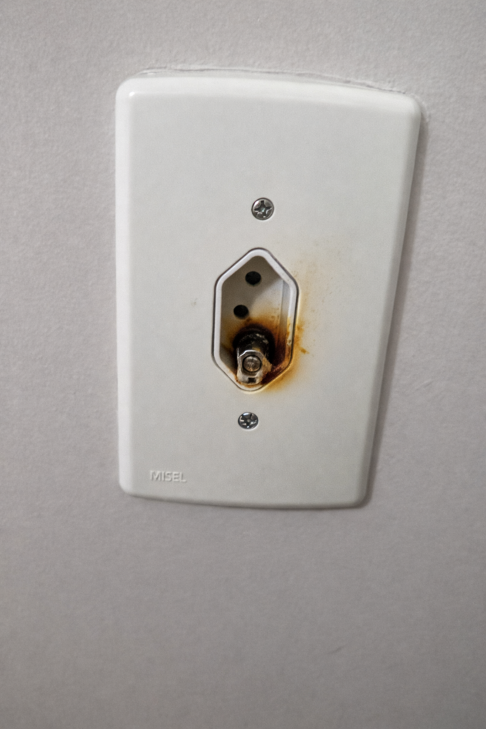 Tomada com sinais de superaquecimento e deformação causada por adaptador inadequado