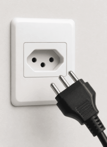 Tomada e plugue elétrico posicionados para conexão segura em instalação residencial