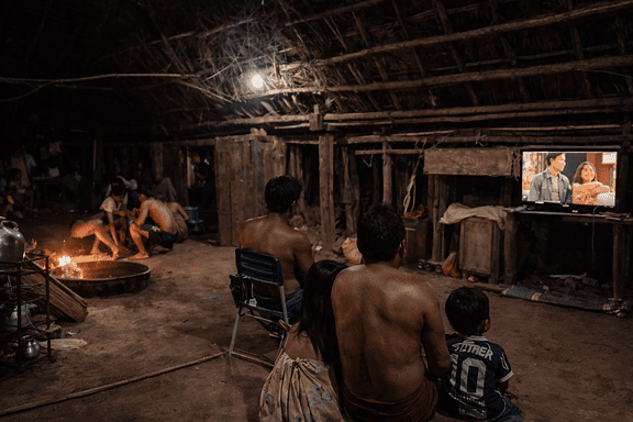 Região remota da Amazônia com casas sem acesso à energia elétrica convencional.